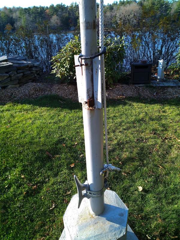 A white metal pole with a chain attached to it

Description automatically generated