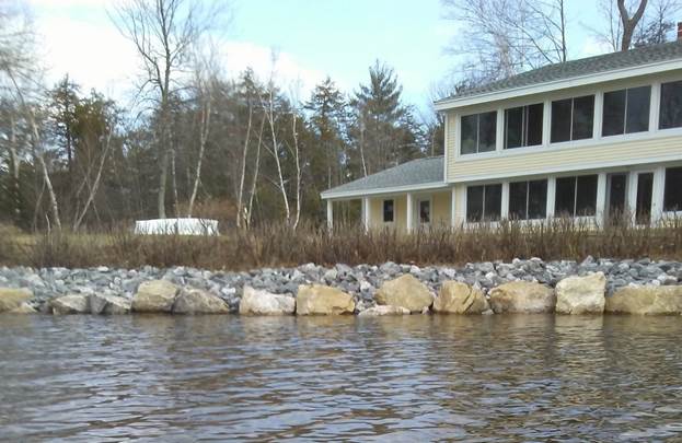 A house with a lake in the background
Description automatically generated