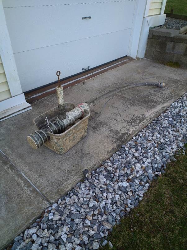 A concrete driveway with a white door

Description automatically generated